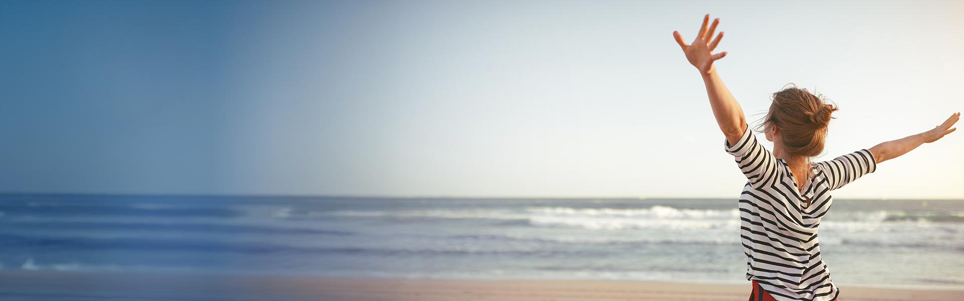 A happy woman looking at the ocean
