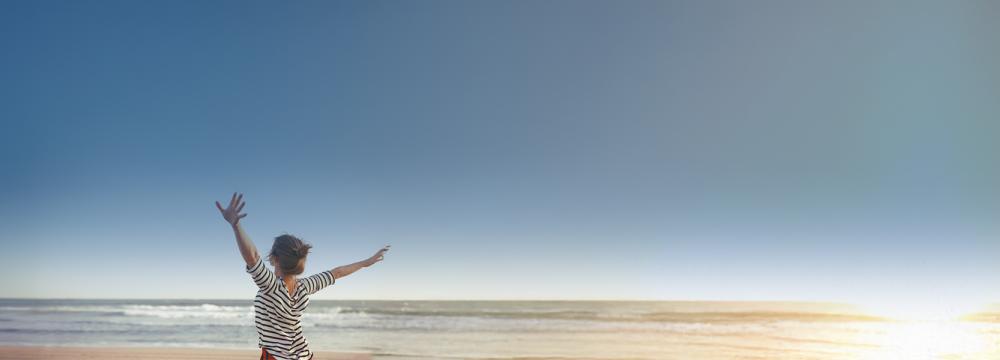 A woman happy looking at the ocean